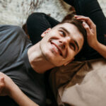 парень лежит у девушки на коленях и улыбается