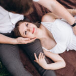 девушка лежит на ноге у парня и смотрит на него